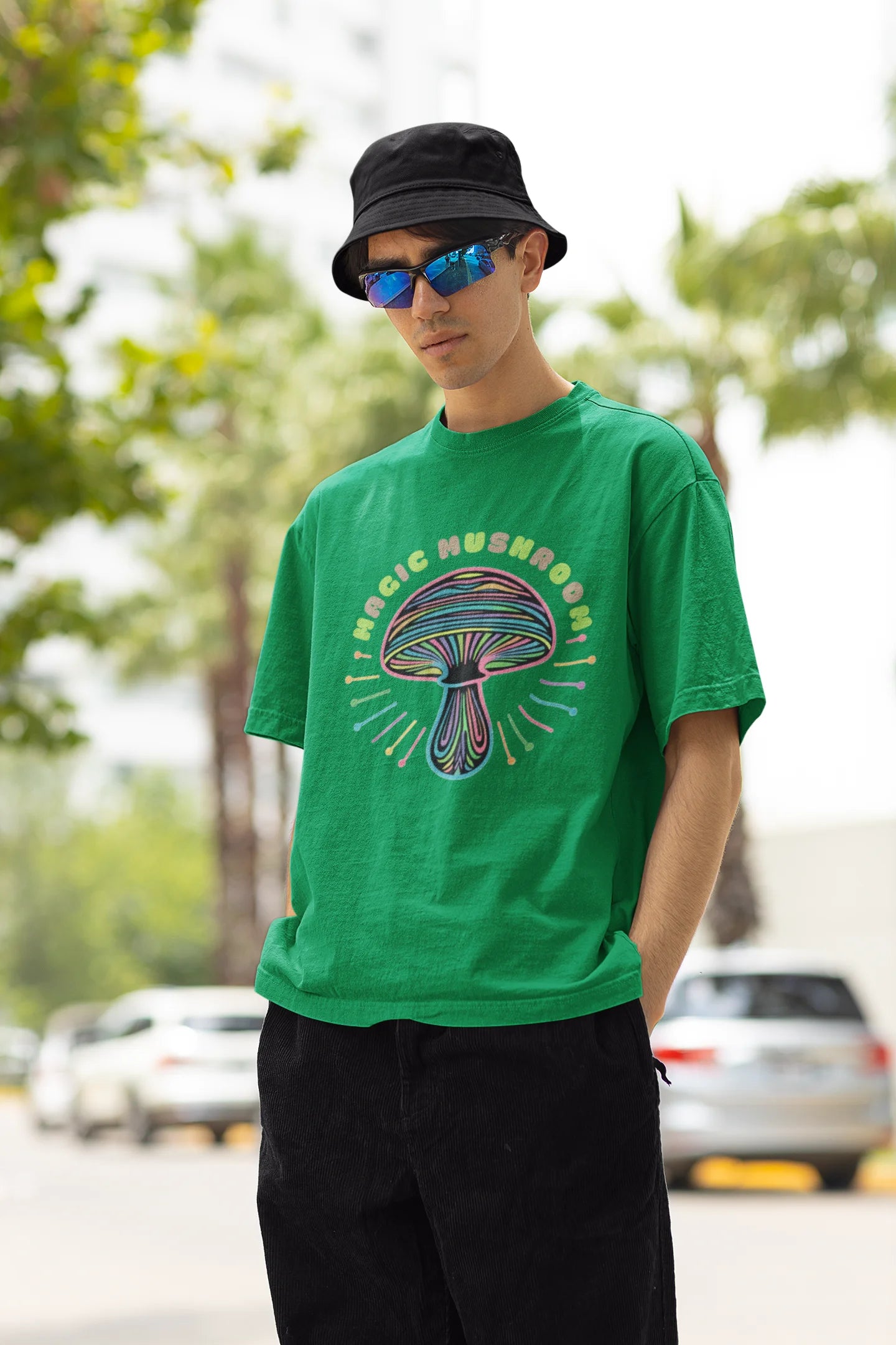 Left side view of a male model wearing a forest green oversized t-shirt featuring a psychedelic magic mushroom with an aura, perfect for a hippie, trance, or groovy style.