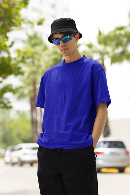 Front view of a male model wearing a royal blue oversized t-shirt with a metal flower design and "Be a Voice, Not an Echo" slogan.