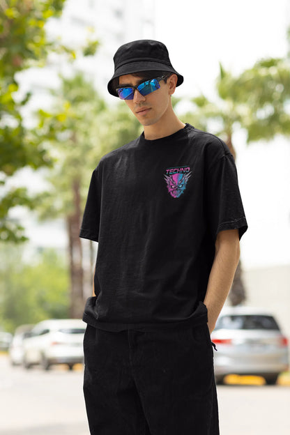 Left side view of a male model wearing an black oversized t-shirt with a stylized Techno Skull design, perfect for rave and party vibes.