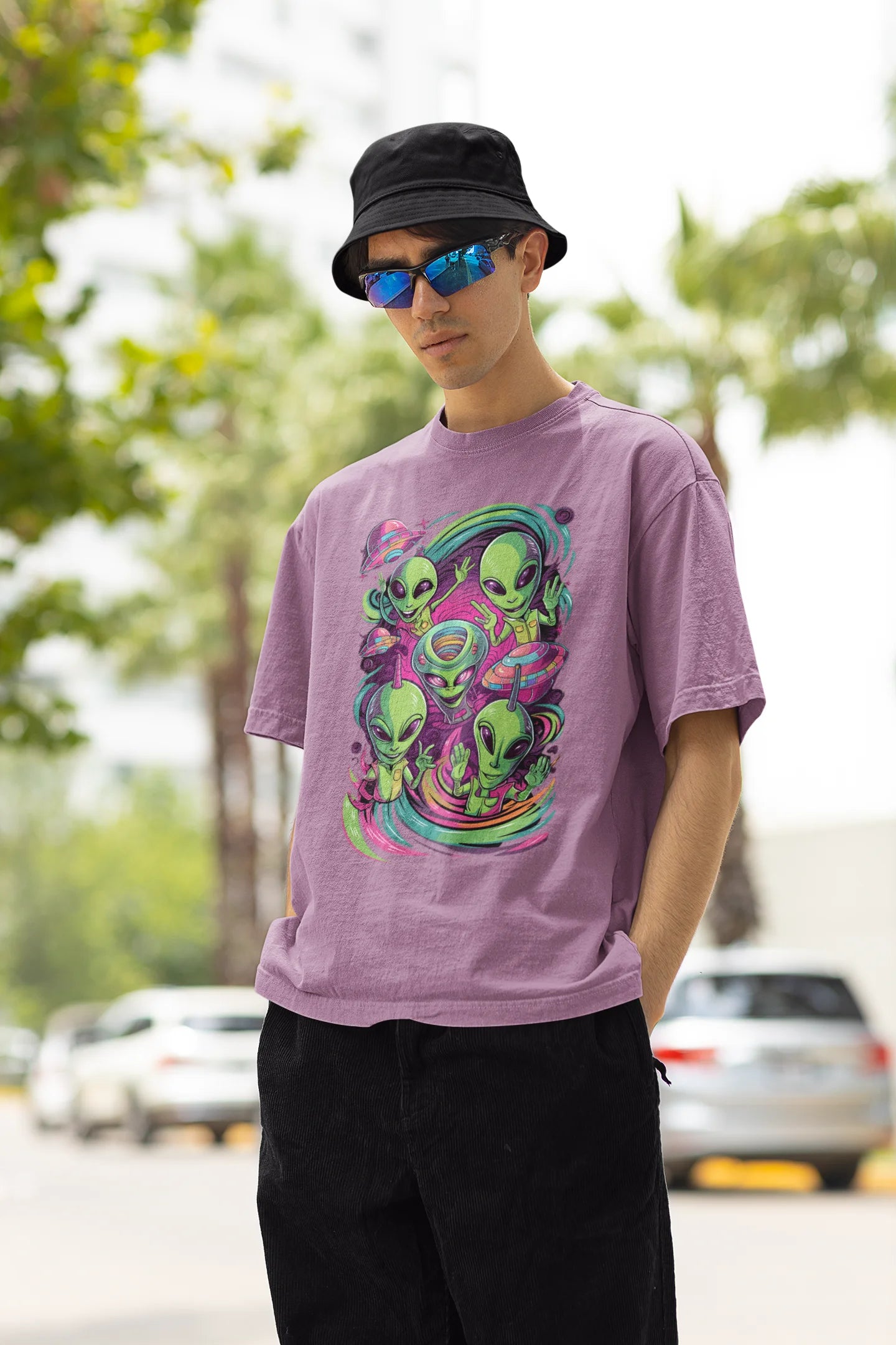 Left side view of a male model wearing a dirty purple oversized t-shirt with a psychedelic design featuring green aliens and spaceships, perfect for a hippie, trance, or groovy style.