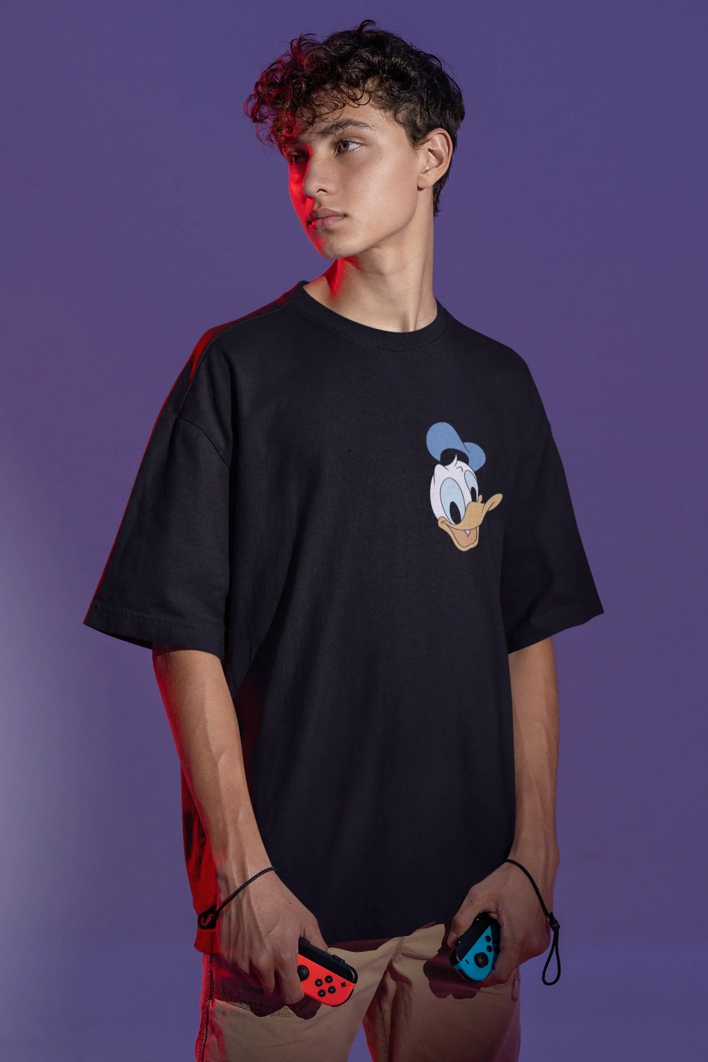Front view of male model wearing black oversized Disney collection t-shirt featuring a classic Donald Duck design.