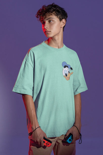 Front view of male model wearing mint green oversized Disney collection t-shirt featuring a classic Donald Duck design.