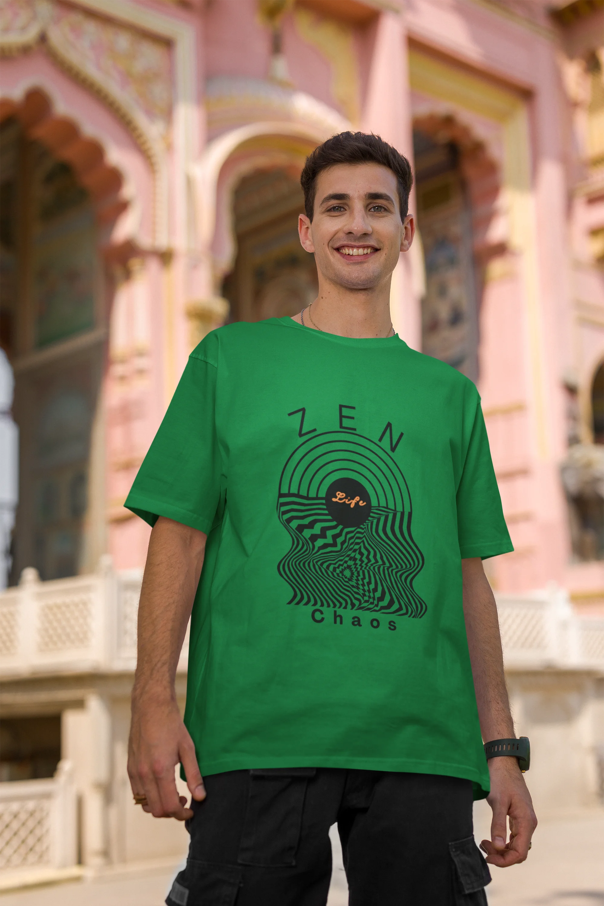 Second front view of a male model wearing an forest green oversized t-shirt featuring an aesthetic design of a setting sun and crashing waves with the text "Zen & Chaos" above it. Ideal for those who love philosophical themes and visually striking clothing.