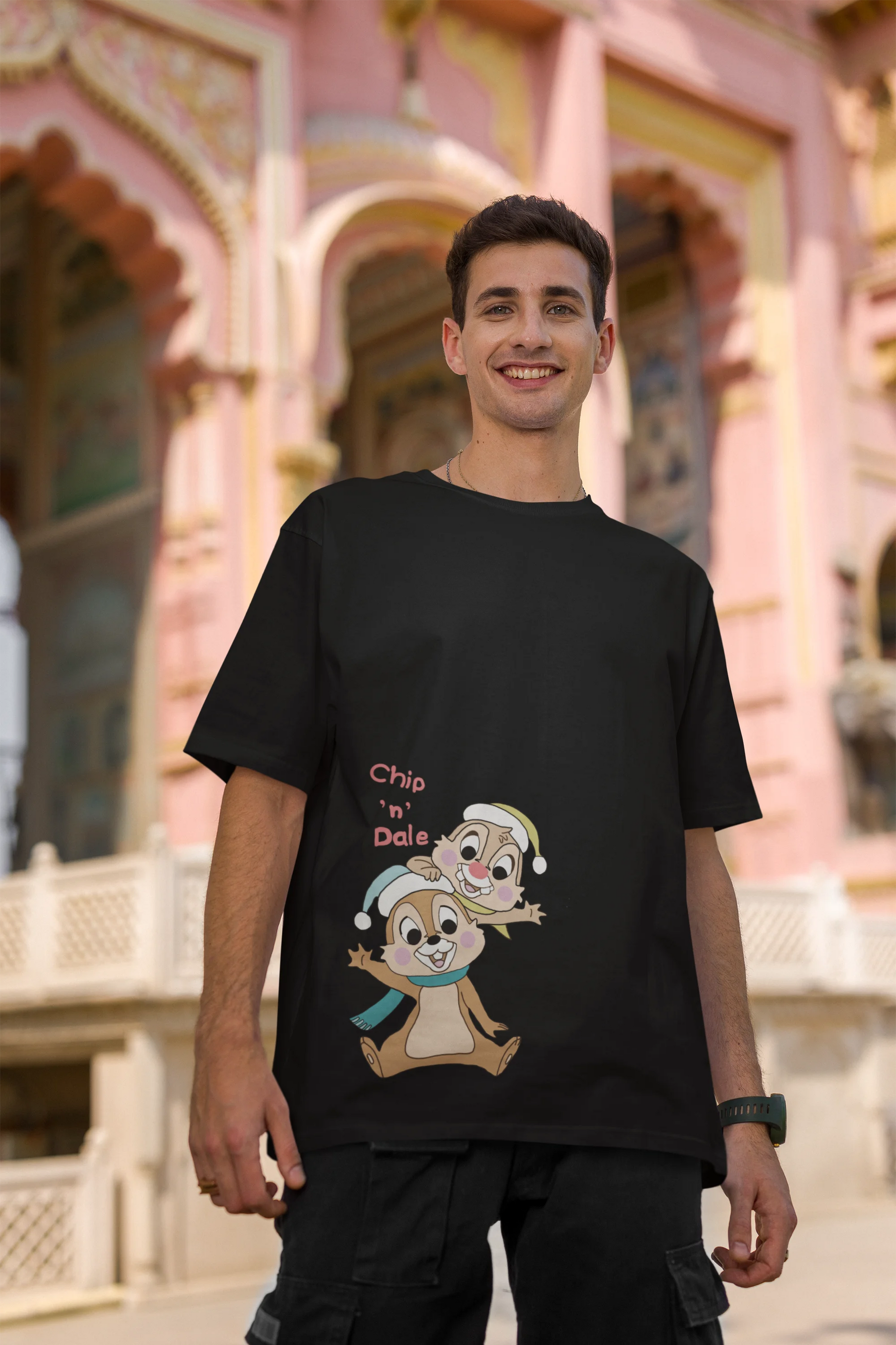 Second image of male model wearing black oversized tee with a Disney's Chip and Dale design, featuring the adorable duo in a playful scene.