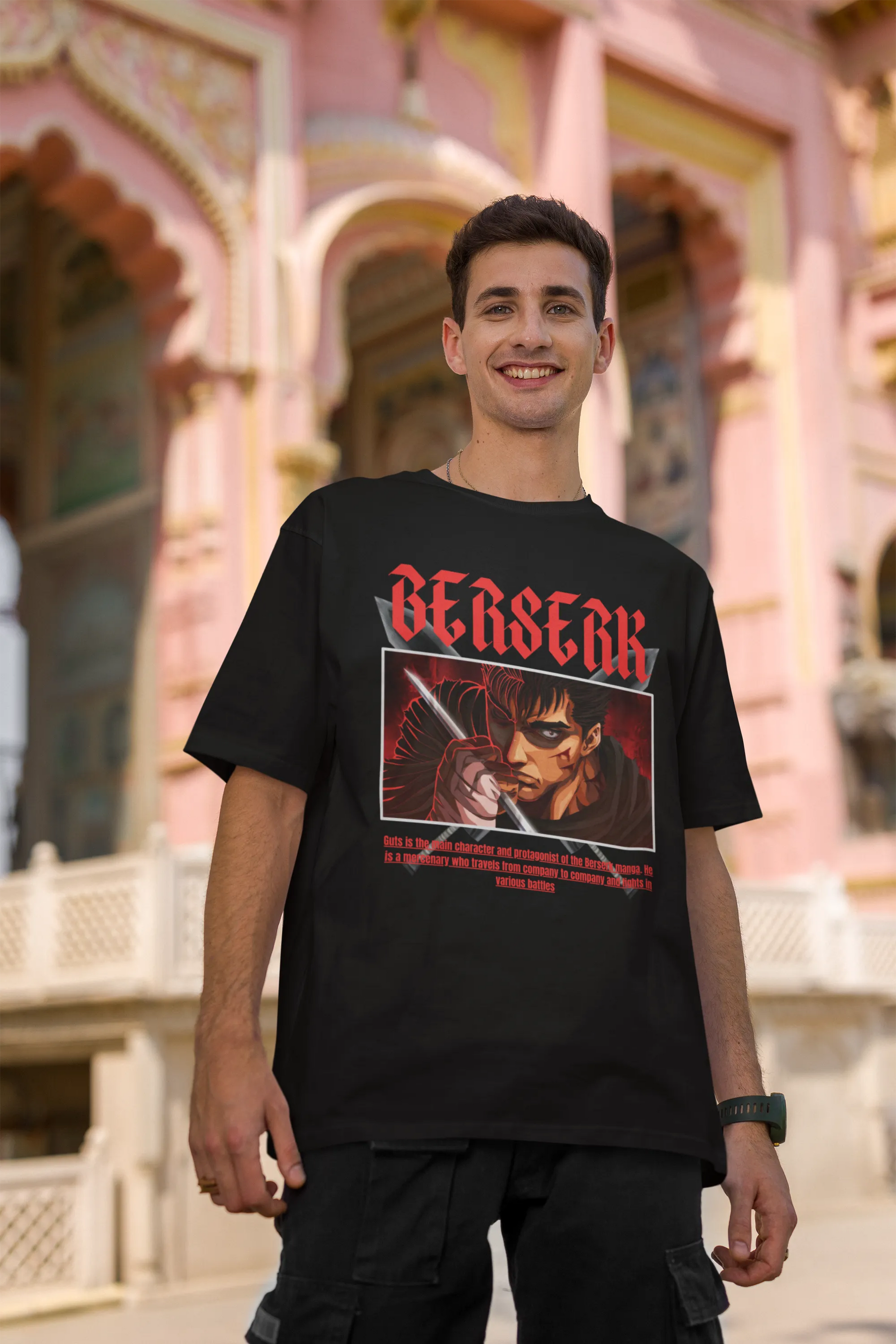 2nd front view of a male model wearing an black oversized t-shirt featuring Guts from the Berserk anime with the text "Berserk" across the design.