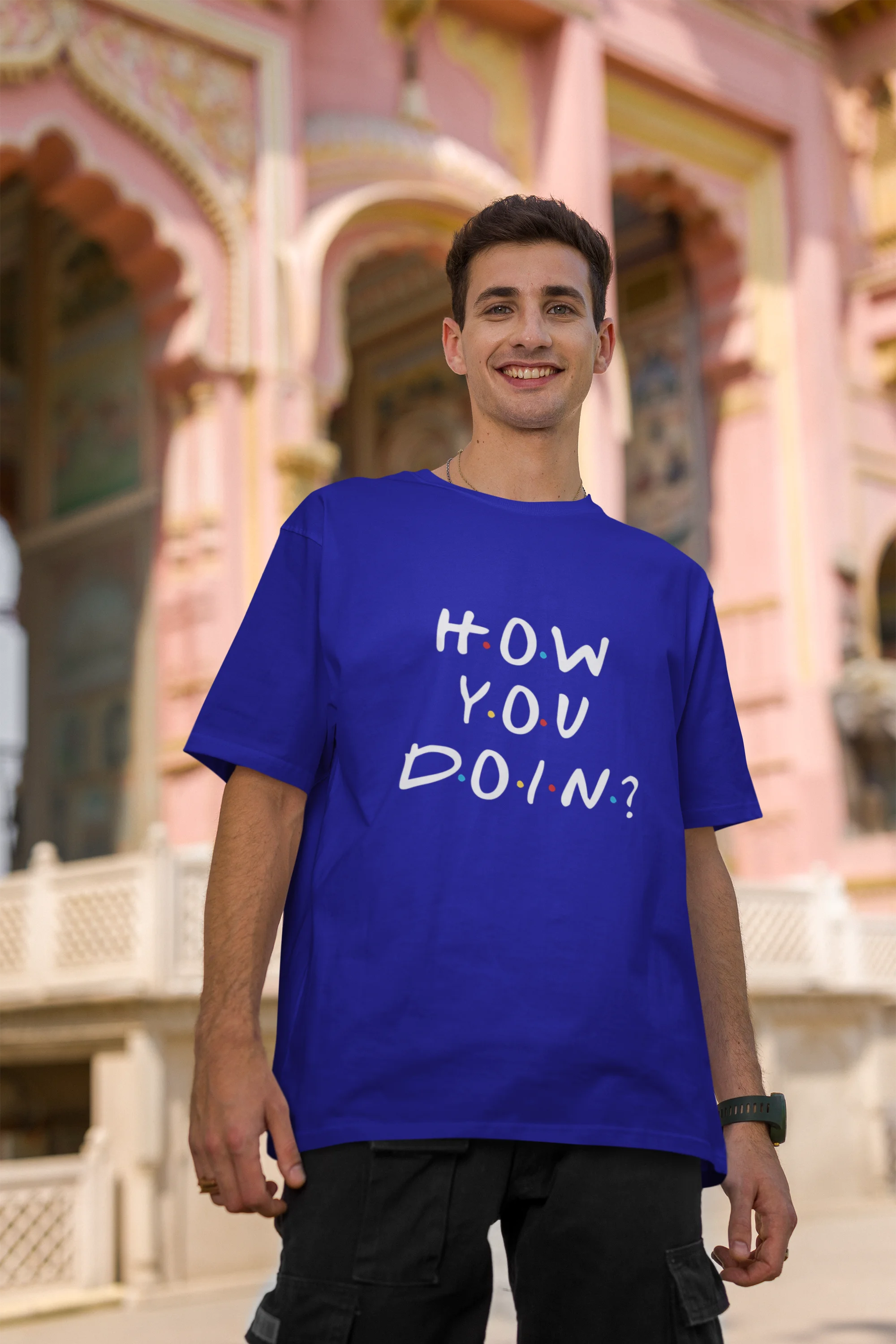 Second image of male model wearing blue oversized t-shirt with F.R.I.E.N.D.S series inspired designs, embodying Joey's famous catchphrase 'How You Doin'?