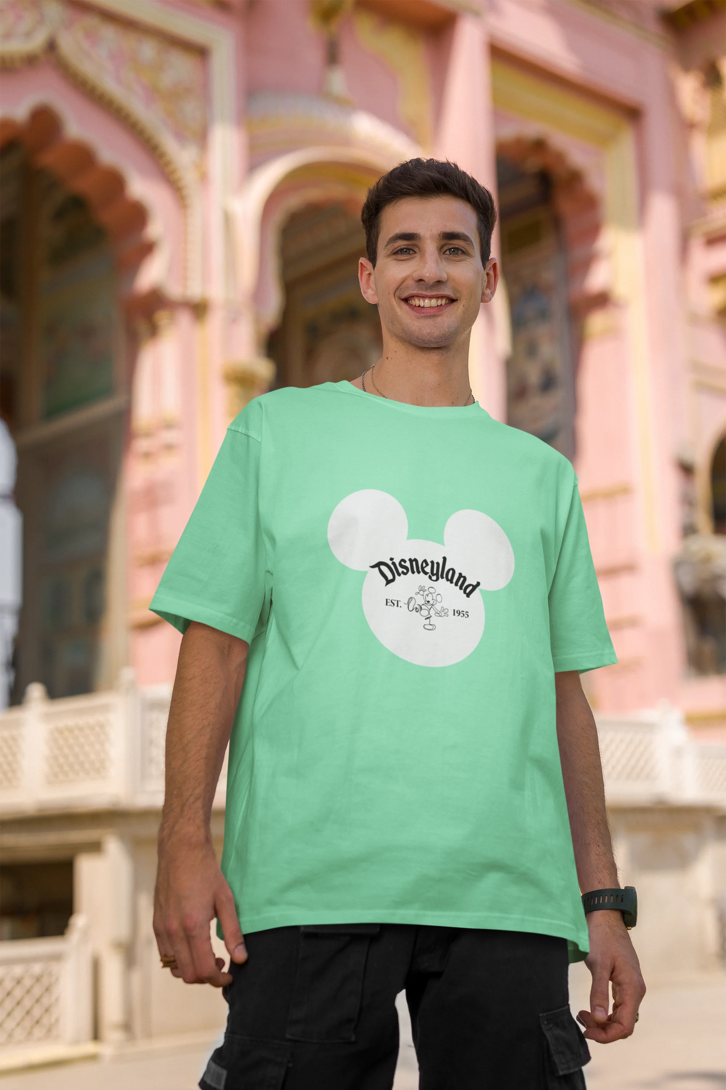 Second image of male model wearing a mint green oversized Disney collection t-shirt featuring a classic Disneyland design.