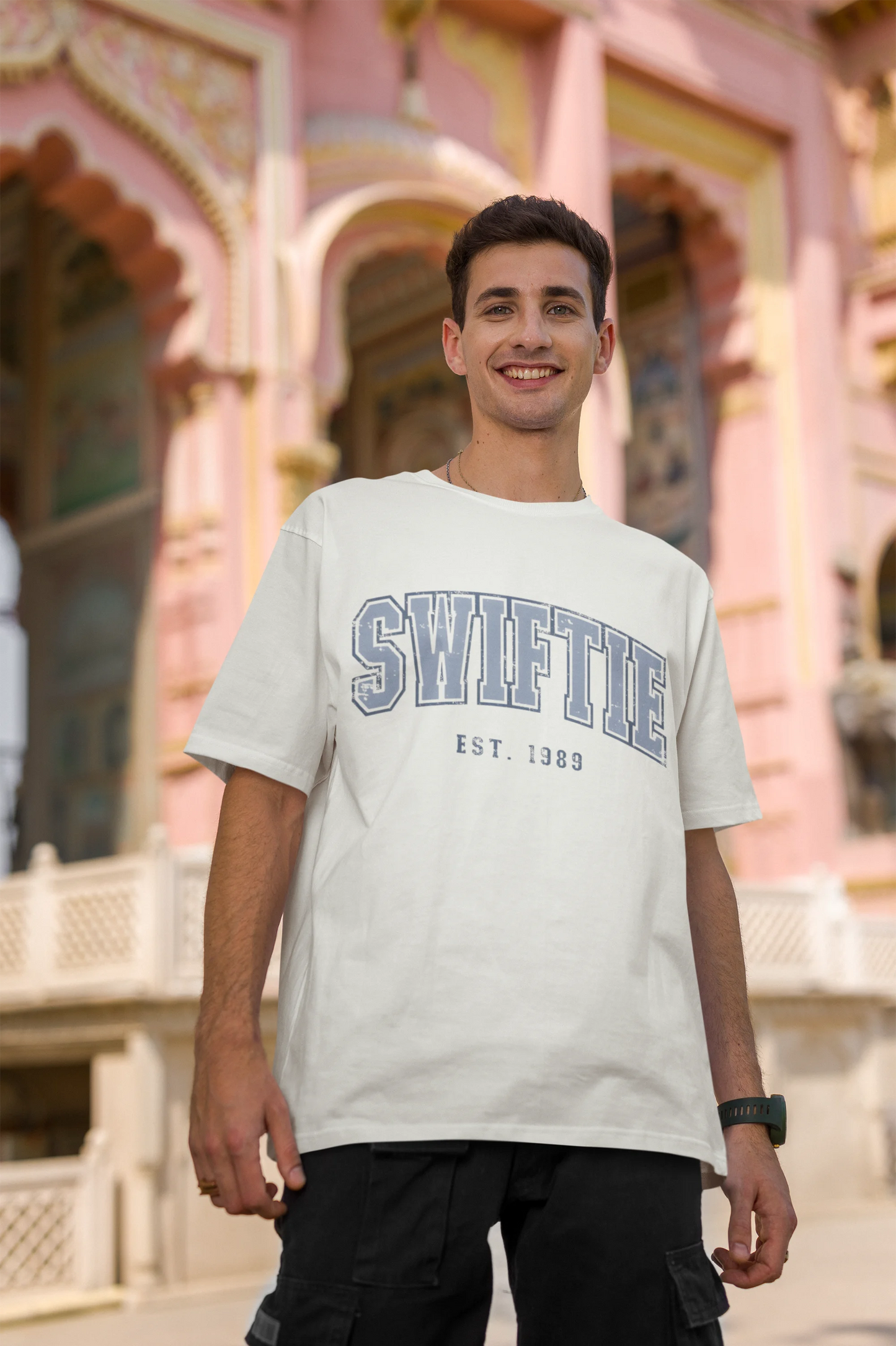 Third image of man wearing off white Oversize T-shirt featuring Swiftie design, taylor's version