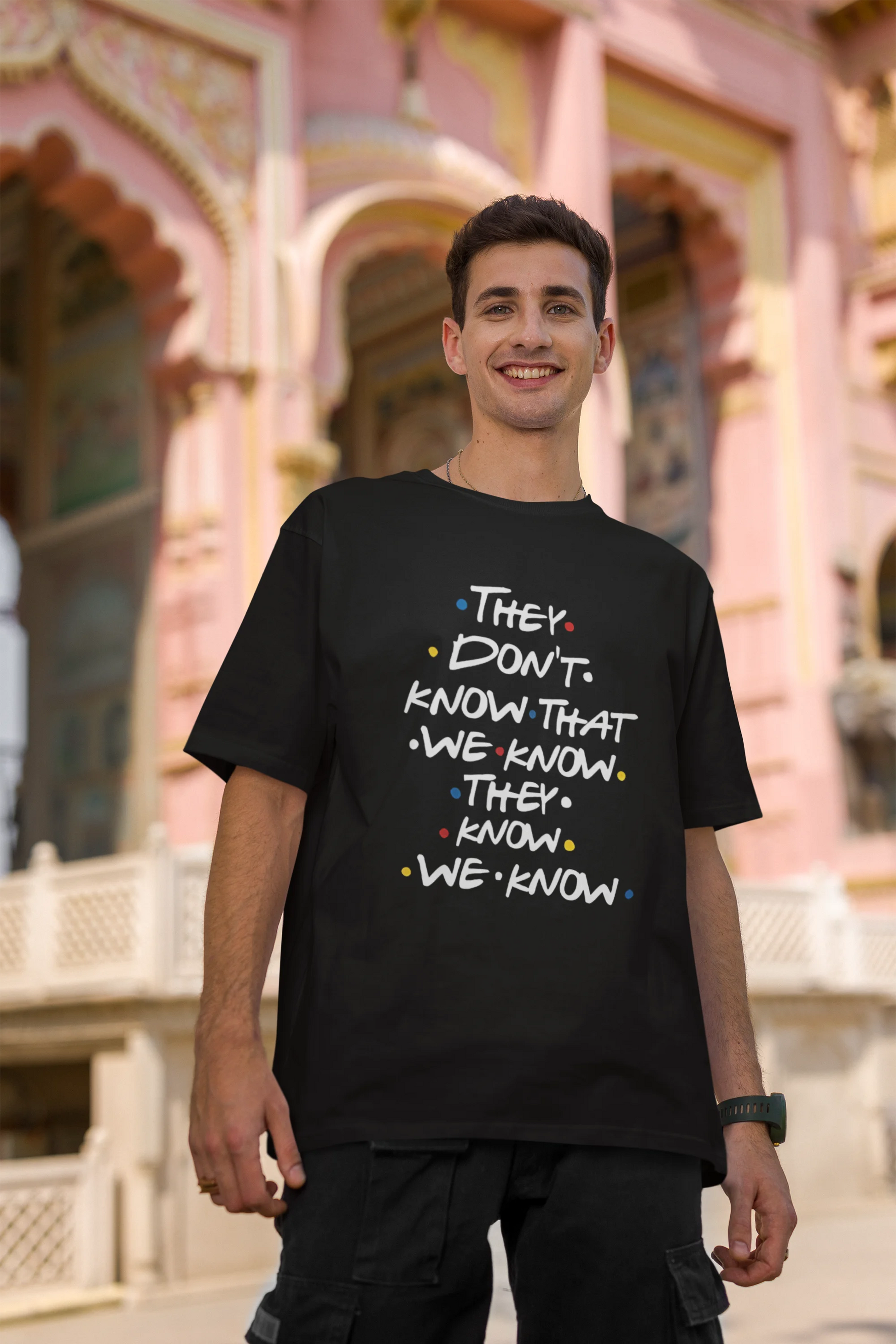 Second image of male model wearing black oversized t-shirt with F.R.I.E.N.D.S series inspired designs, embodying Phoebe's unique humor with the quote 'They Know We Know'