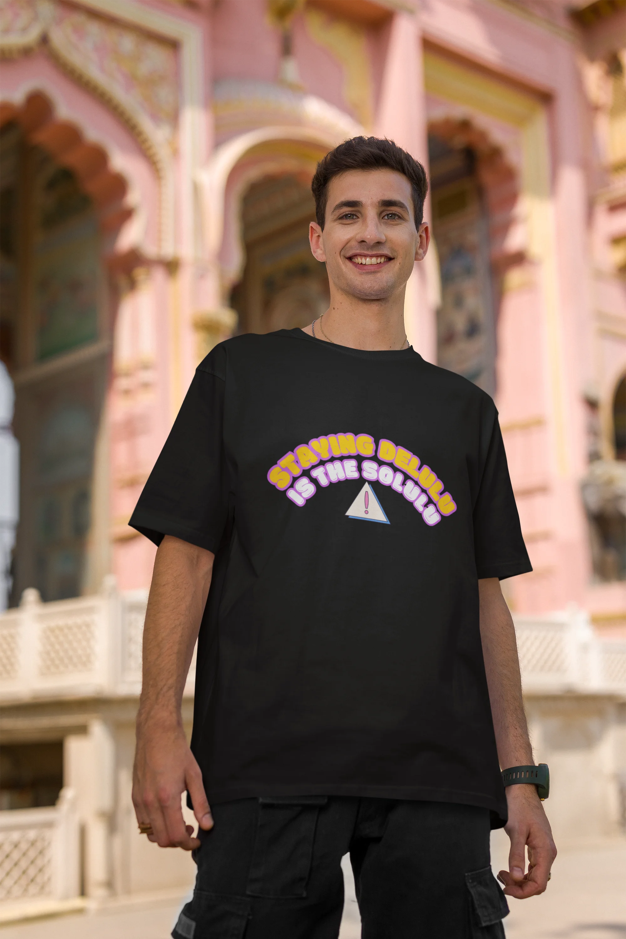 Second front view of male model wearing a black oversized t-shirt with the hilarious message "Stay Delulu" in a bold design. Ideal for those who love trendy slang and lighthearted humor.