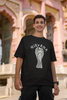 First front image of male model wearing a black oversized t-shirt featuring a design of a winged angel with the text 