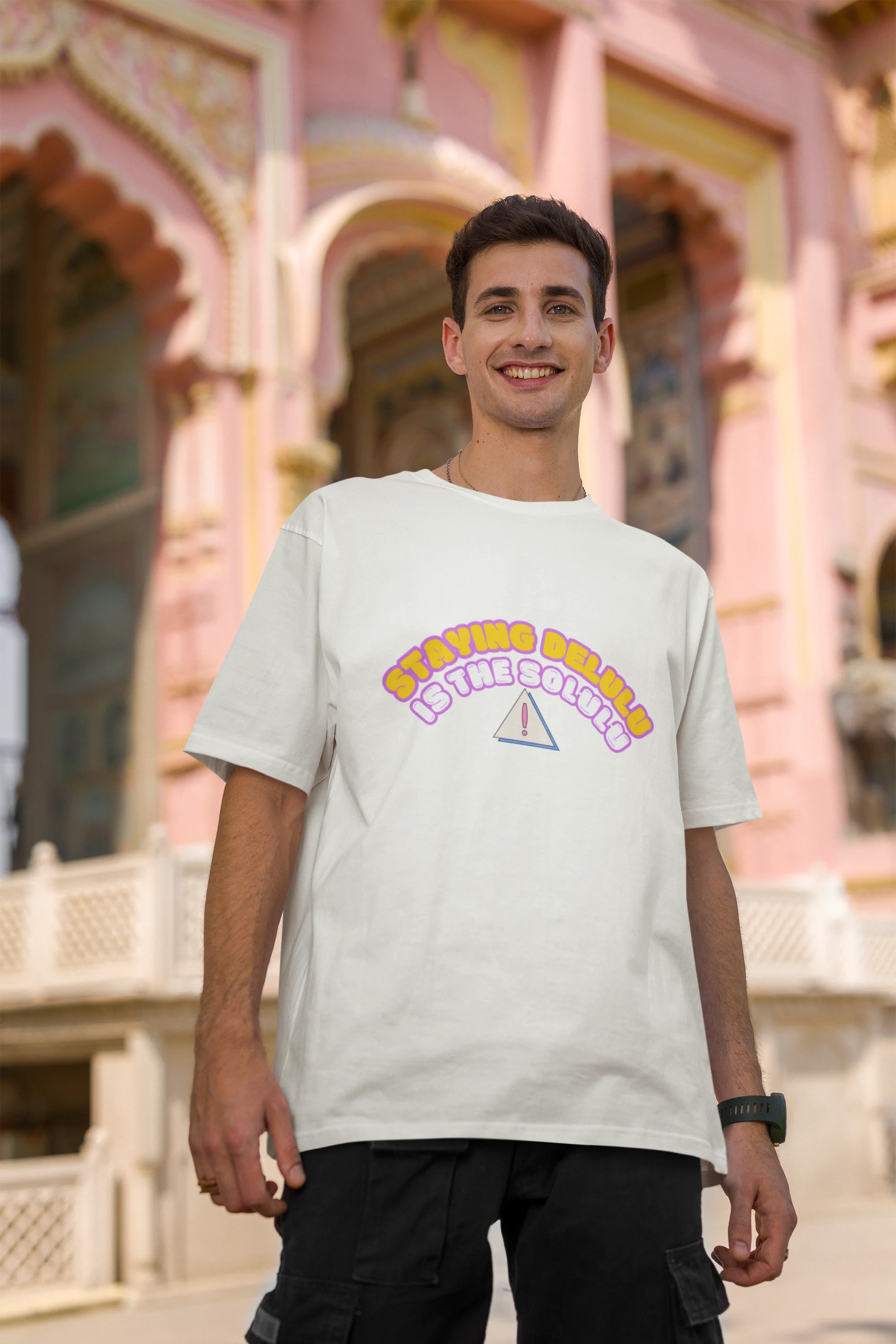 Second front view male model wearing an off-white oversized t-shirt with the hilarious message "Stay Delulu" in a bold design. Ideal for those who love trendy slang and lighthearted humor.